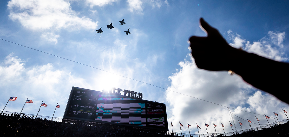 Thumbs up in front of sky with fly over at Kyle Field